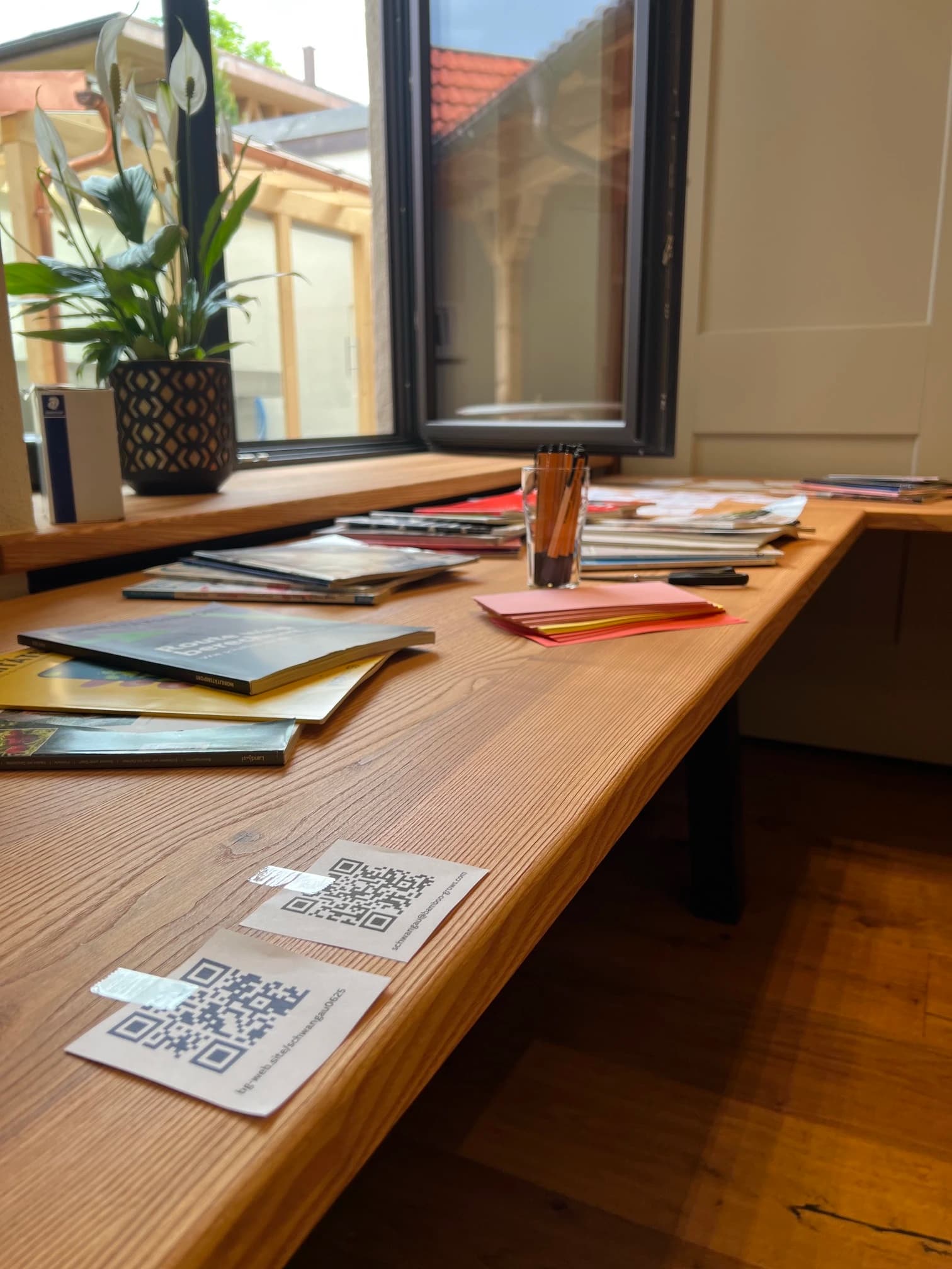 Materialtisch im Strategieworkshop mit Fachliteratur, Moderationskarten und QR-Codes zur Online-Beteiligung
